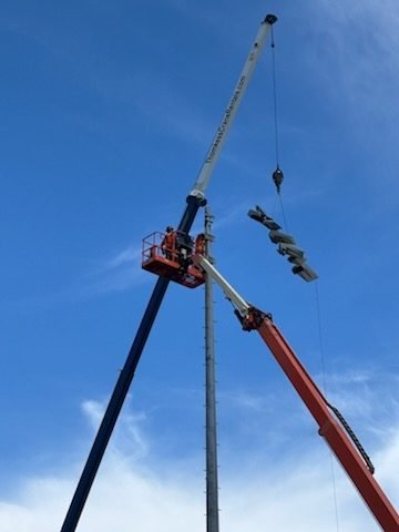 Crane and basket installing sports lighting fixtures