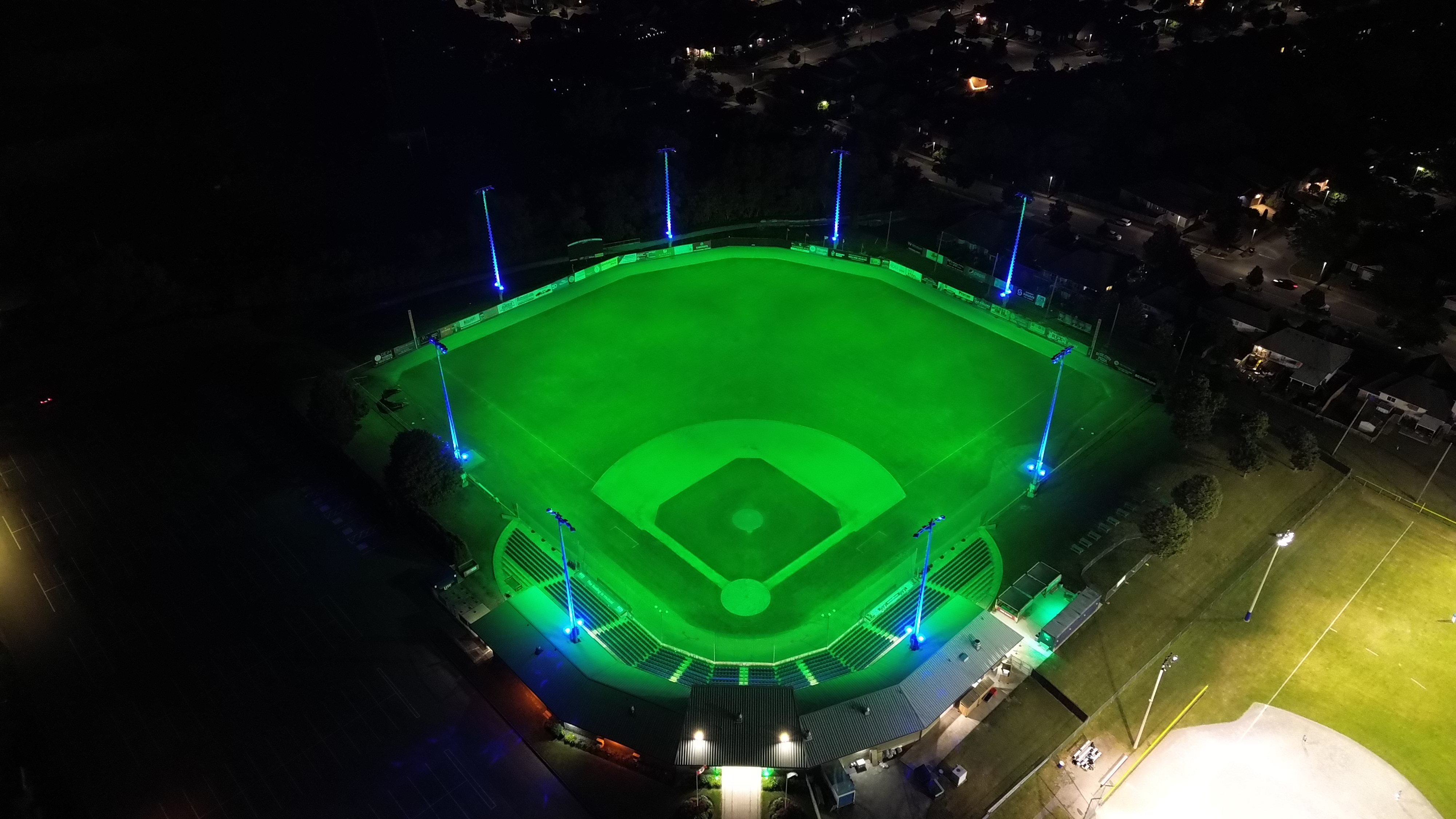 Green field with blue poles from stands